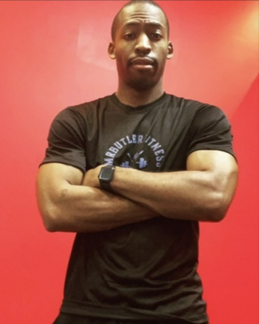 Coach at MrButlerFitness LLC standing with arms crossed in a MrButlerFitness training shirt